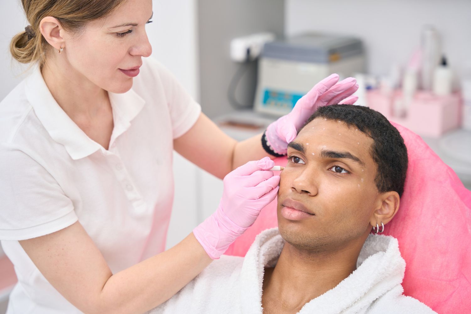 Erfahrener Arzt, der männlichen Kunden auf kosmetische Eingriffe vorbereitet